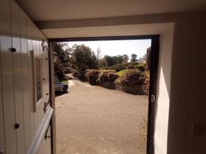 une porte ouverte d'une maison avec une allée dans l'établissement Pandy cymunod, à Bryngwran