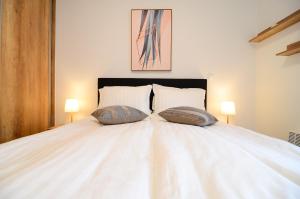a large white bed with two pillows on it at Luna Deluxe Bjelasnica & Free Parking in Bjelašnica