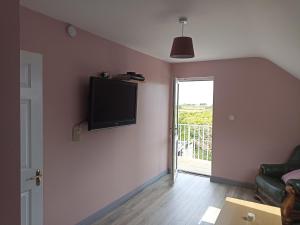 a living room with a flat screen tv on the wall at Foreen Lodge, Achill Island in Achill