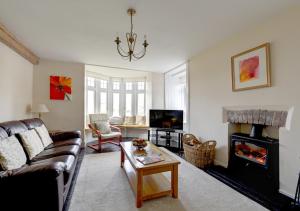 a living room with a couch and a fireplace at Rhiwlas in Pennal