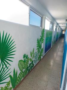 a hallway with a mural of plants on the wall at Blue Coconut Cancun Hotel in Canc&uacute;n