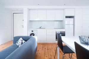 uma sala de estar com um sofá azul e uma cozinha em Oporto Near Violin no Porto