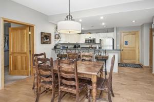 kuchnia i jadalnia z drewnianym stołem i krzesłami w obiekcie Aspenwood Lodge #205 Condo w mieście Edwards