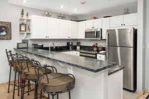 kuchnia z białymi szafkami i lodówką ze stali nierdzewnej w obiekcie Aspenwood Lodge #205 Condo w mieście Edwards