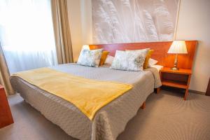 伊格納利納的住宿－蘇維德拉酒店，一间卧室配有一张带黄色毯子的大床