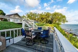 een balkon met een tafel en stoelen en de oceaan bij Cozy Lakefront Cottage in Huron