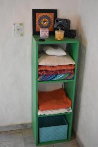 a green shelf with folded towels in a room at Luz de Cabaña in Carpintería