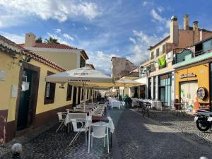 an empty street with tables and chairs and umbrellas at Fort Traditional Guest House in Funchal