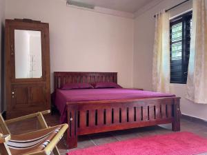 sypialnia z łóżkiem, krzesłem i oknem w obiekcie Deesha Homes w mieście Wayanad