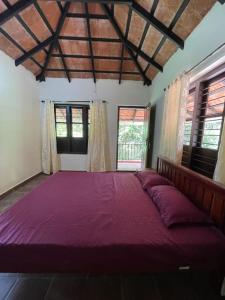 a large purple bed in a room with windows at Deesha Homes in Wayanad
