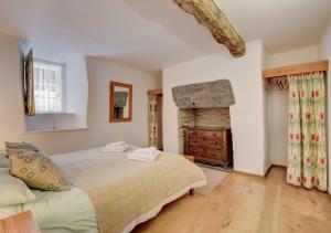 1 dormitorio con 1 cama y chimenea en Ysgubor Newydd, en Machynlleth