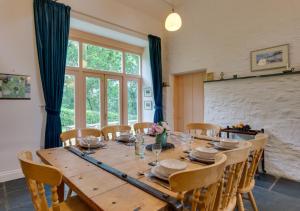 a dining room with a wooden table and chairs at Stabal Pant y Lludw in Machynlleth