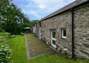 an old brick building with a yard next to it at Stabal Pant y Lludw in Machynlleth