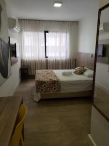 Schlafzimmer mit einem Bett und einem Spiegel in der Unterkunft Flat Imóvel na Praia de Camburi , Vista lateral pro Mar in Vitória