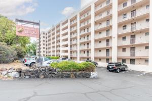 un gran edificio de apartamentos con coches aparcados en un aparcamiento en Kailua Village Resort 605, en Kailua-Kona