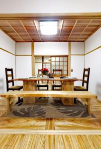 a dining room with a wooden table and chairs at Bighem Maison in Izumi-Sano