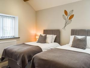 two beds sitting next to each other in a bedroom at The Old Fox Lodge in Ruabon