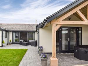 an extension to a home with a patio and a house at The Old Fox Lodge in Ruabon