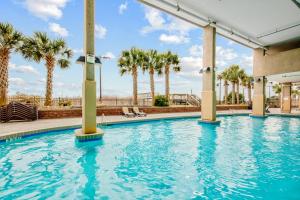 a swimming pool at a resort with palm trees at Bahama Sands Condos in Myrtle Beach