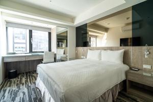 台北市にあるHotels Here - Taipeiの大きなベッドと机があるホテルの部屋 +29枚の写真