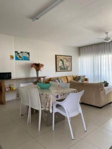 - un salon avec une table, des chaises et un canapé dans l'établissement Bouganville Guest House BC, à Balneário Camboriú