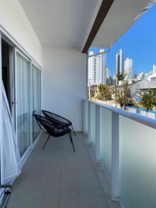 a balcony with a chair and a view of the city at Bouganville Guest House BC in Balneário Camboriú