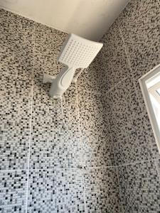 ducha con luz en la pared del baño en Bouganville Guest House BC, en Balneário Camboriú