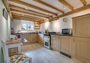 a large kitchen with wooden cabinets and a table at Gellilwyd Fach in Dolgellau