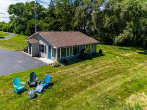 a small house with blue chairs in the yard at Cozy Lakefront Cottage in Huron +31 photos