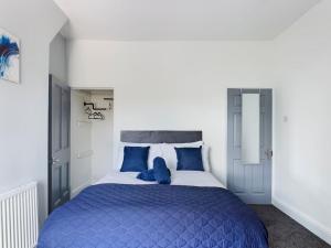 1 dormitorio azul y blanco con 1 cama grande en Whitmore House By RMR Accommodations - Newly Refurbed - Modern - Parking - Central en Etruria