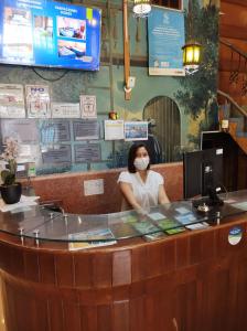 una mujer usando una máscara en un mostrador en un restaurante en Hotel Virrey Pucallpa EIRL, en Pucallpa