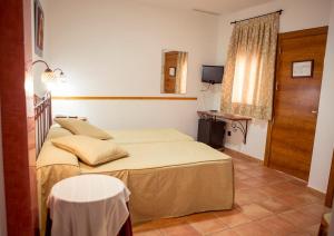a bedroom with two beds and a table and a window at La Galerica in Puerto de Mazarrón