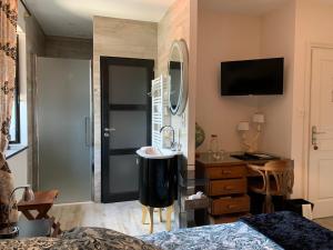 1 dormitorio con cama, lavabo y espejo en Logis de La Roche - Niort - Chauray en Chauray