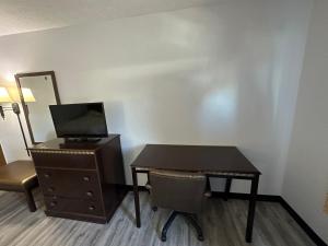 a room with a desk and a table and a mirror at I65 Studio Suites in Scottsburg