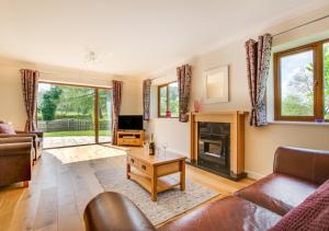 a living room with a couch and a fireplace at Bwthyn Bryn yr Aber in Bala