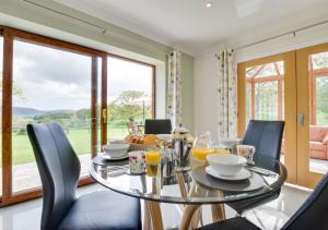 a dining room with a glass table and chairs at Bwthyn Bryn yr Aber in Bala