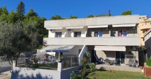 a large white building with tables and chairs at HM Apartmani in Bar