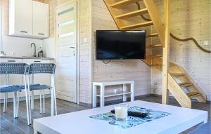 Una sala de estar con una mesa y un televisor en una pared. en 2 Bedroom Gorgeous Home In Rewal, en Rewal