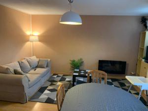 sala de estar con sofá y mesa en Beau T3 place parking, vue dégagée proche centre, en Luchon
