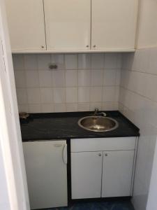 a small bathroom with a sink and white cabinets at SB Apartman in Sremska Mitrovica