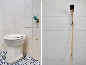 a bathroom with a toilet and a cleaning brush at SPOT ON 91775 Pondok 14 Syariah in Bandung