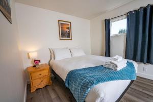 a small bedroom with a bed and a window at Downie Cottage by Revelstoke Vacations in Revelstoke