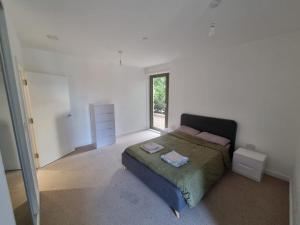 a white bedroom with a bed and a window at ExCel London - Fantastic Garden - 3 Bedroom-Condo in Beckton