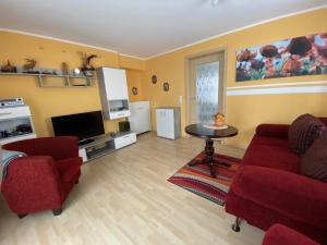 - un salon avec un canapé rouge et une table dans l'établissement Ferienhaus Auerswalde, à Lichtenau