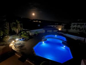 uma piscina à noite com a lua ao fundo em Beautiful 2 Bed Apartment in Peyia Valley, Paphos em Peyia