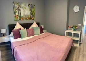 a bedroom with a large bed with a pink blanket at Family Apartment in Karlsruhe