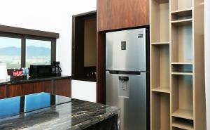 a kitchen with a stainless steel refrigerator and a counter at Hotel Marea Vista in Ensenada