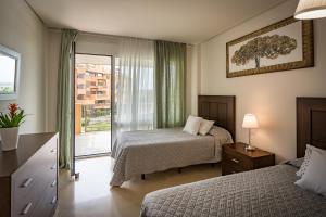 Una habitación de hotel con dos camas y una ventana. en Sotogrande - Ribera del Marlín, en Sotogrande 37 fotos más