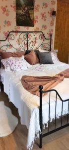 的住宿－Casuta de sub stanca Apuseni，一张带黑色框架和白色床单及枕头的床