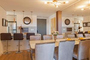 a kitchen and dining room with a table and chairs at Cityhome Bav Residenz Gramado in Gramado